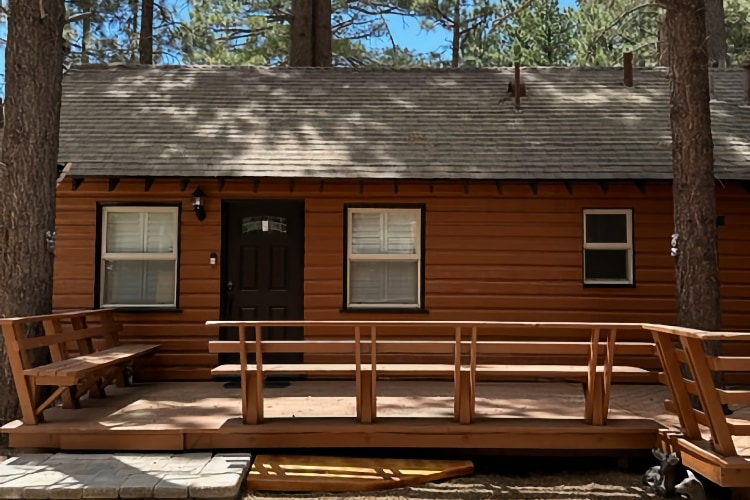 exterior of 917 E Fairway; tree-covered house with wood cabin look and large wooden porch